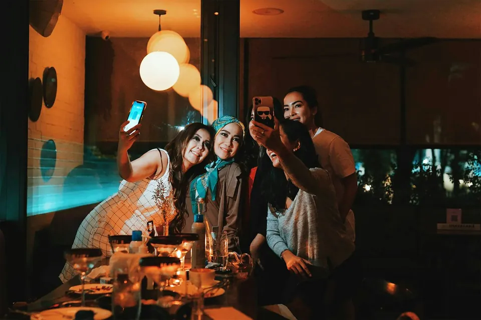 Friends squeezed in for a selfie at a candlelit table