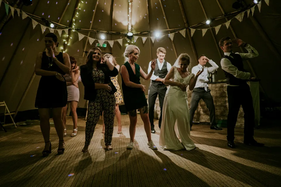 Guests dancing under bunting in a tent