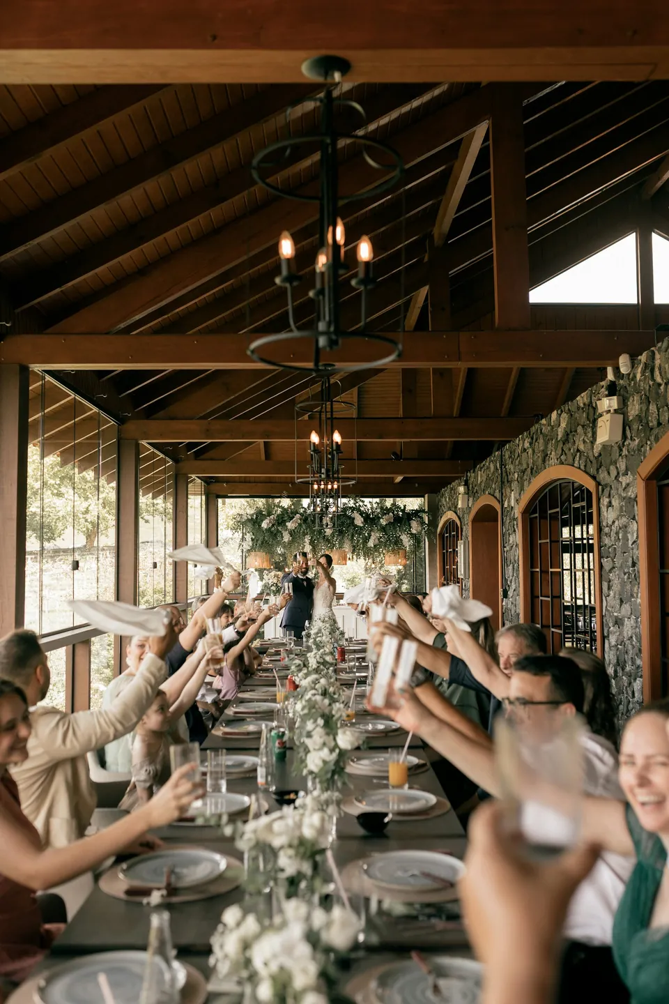 Guests raising their glasses under festoon lights